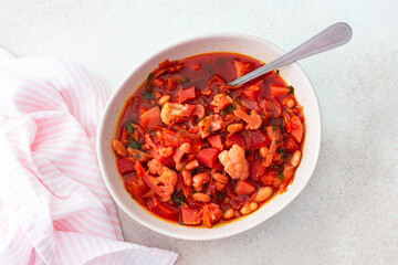 Red soup with beet, beans and vegetables and cauliflower, chickpea cutlets and mixed salad with avocado, delicious hearty breakfasts or lunches, top view of a set table with food
