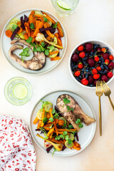 Baked silver carp with roasted carrots, zucchini, beets, and garlic, accompanied by fresh seasonal...
