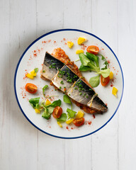 Baked mackerel stuffed with vegetables and tomato. Top view table.