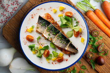 Baked mackerel stuffed with vegetables and tomato. Top view table.