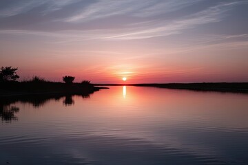 Naklejka premium Tranquil Sunset Reflection on Calm Waters with Isolated Scenic Background
