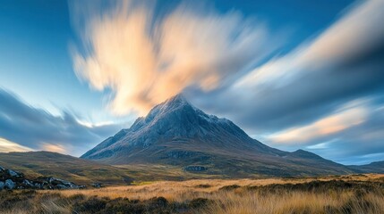 A majestic mountain surrounded by dynamic clouds and golden grassland at dusk.