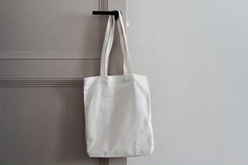Eco friendly concept with white canvas tote bag hanging on door knob with two toned colored, Eco...