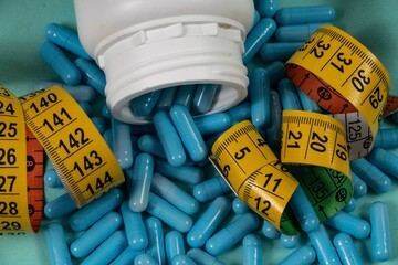 bottle of pills, some of which spilled onto a light blue surface