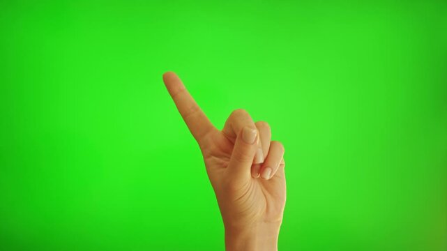 Finger wag. Restriction sign. Rejection signal. Female hand warning on green background.