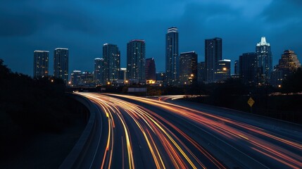 Night cityscape featuring illuminated skyscrapers and light trails from traffic.