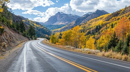 Fototapeta premium A mountain road with autumn foliage lining the route, showcasing vibrant fall colors and a tranquil journey through nature.