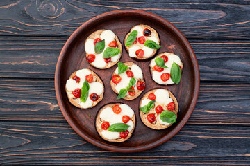 Italian mini pizza . Aubergine (eggplant ) with mozzarella cheese and basil . On rustic background