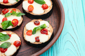 Italian mini pizza . Aubergine (eggplant ) with mozzarella cheese and basil . On rustic background