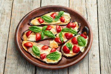 Italian mini pizza . Aubergine (eggplant ) with mozzarella cheese and basil . On rustic background