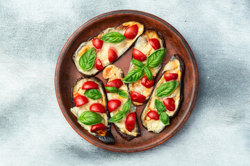 Italian mini pizza . Aubergine (eggplant ) with mozzarella cheese and basil . On rustic background