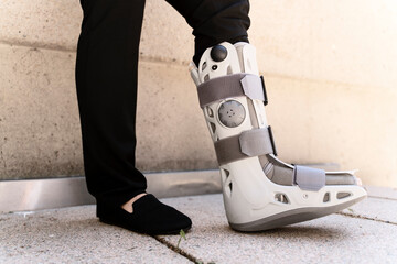 Businesswoman wearing ankle brace standing outdoors