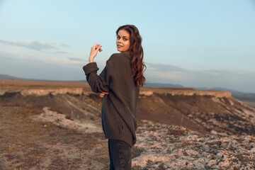 Empowered woman standing confidently on mountain peak gazing into the horizon