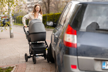 Young mother having a mishap while pushing baby stroller on sidewalk