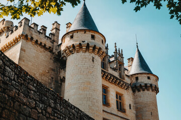 Fototapeta premium A historic castle with turrets and stone walls stands majestically under clear sky