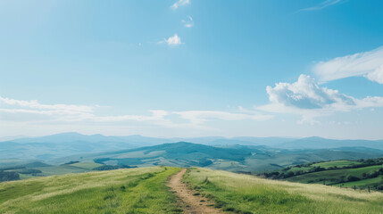 Fototapeta premium Scenic pathway through rolling hills and vast blue sky