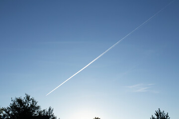 A trail of a huge plane in the sky. The evening sky where the plane flew