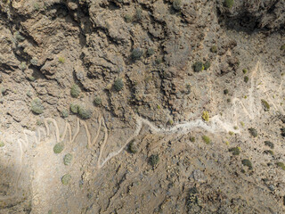 Aerial view of the trail through the mountains to Guigui beach, pristine black sand beach, Gran Canaria. Spain. Scenic trail