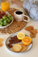 Pumpkins, various food and drinks, fall decorations, books and candles on the table. Fall hygge at home. Selective focus.