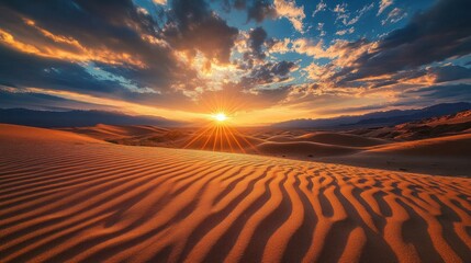 Naklejka premium A stunning sunset over sand dunes, showcasing vibrant colors and textured patterns.