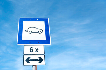 Electric Vehicle Charging Station Sign Against a Clear Blue Sky on a Sunny Day