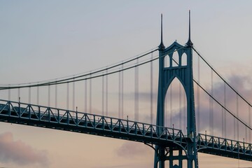 Detailed view of the St. Johns Bridge in Portland, Oregon, with a clear sky background during sunset