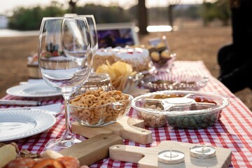 Picnic table with snacks and wine glass.