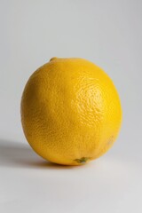 A single lemon sitting on a white surface