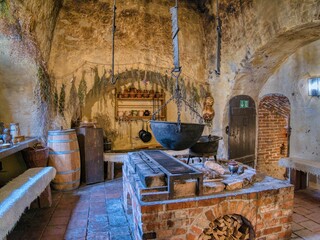 Medieval Kitchen Interior with Cooking Pot and Herbs