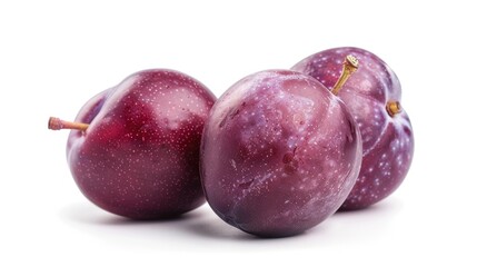 Fototapeta premium Three juicy plums sit together on a white surface, waiting to be eaten or used in a recipe