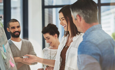 Obraz premium Business people, sticky notes and talking on whiteboard in office, meeting and discussion for sales growth. Staff, workshop and team for support planning in workplace, strategy process and project