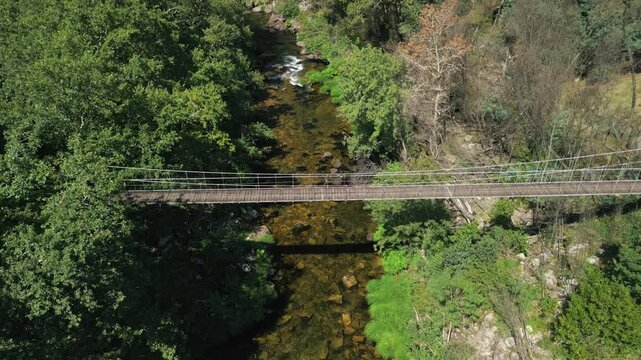 Drone footage of Calvelo Suspension Bridge across River Lerez on a sunny day In Pontevedra, Spain