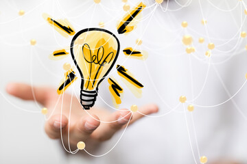 Hand reaching out to a lightbulb with a network of connections around it New ideas and solutions...