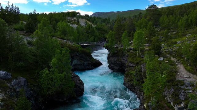 Pull-back drone footage of the flowing Tora River in daytime in Billingen, Skjak, Oppland, Norway