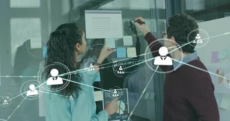Animation of network of connections with icons over diverse colleagues taking notes in office - Powered by Adobe