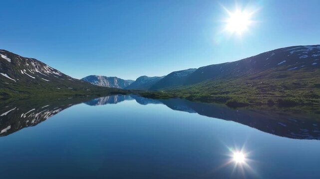 Drone view of Otta river on a sunny day surrounded by mountains with reflection in water in Norway