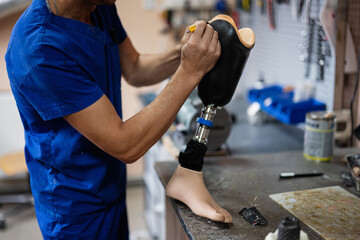 Technician crafting a prosthetic leg in workshop setting