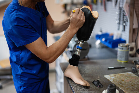 Technician crafting a prosthetic leg in workshop setting