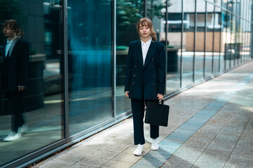 A Young Professional Walking Confidently in a Business District During the Morning Light