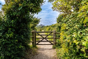 Countryside path with wooden gate and distant castle