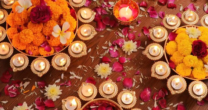 Closeup top footage of the candles and colorful decorations for Diwali festival, on a wooden floor