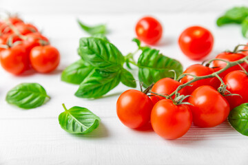 Fresh cherry tomatoes and fresh green basil on a textured background. Tomato sauce. Vegan. Ingredients for salad. Organic food. Place for text. Copy space.