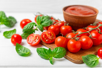Fresh cherry tomatoes and fresh green basil on a textured background. Tomato sauce. Vegan. Ingredients for salad. Organic food. Place for text. Copy space.