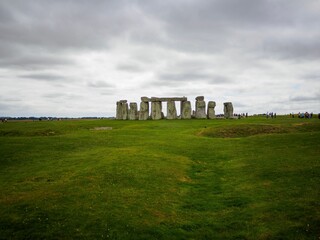 Stonehenge with a cloudy sky and green grass
