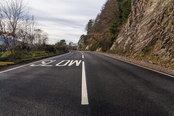 Mountain road near Inverness Schotland. With a road mark to slow down the speed.