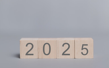 2025 on wooden table. 2025 New Year. Wooden blocks 2025 on neutral grey background. Start new year 2025 with goal plan, goal concept, action plan, strategy, new year business vision.