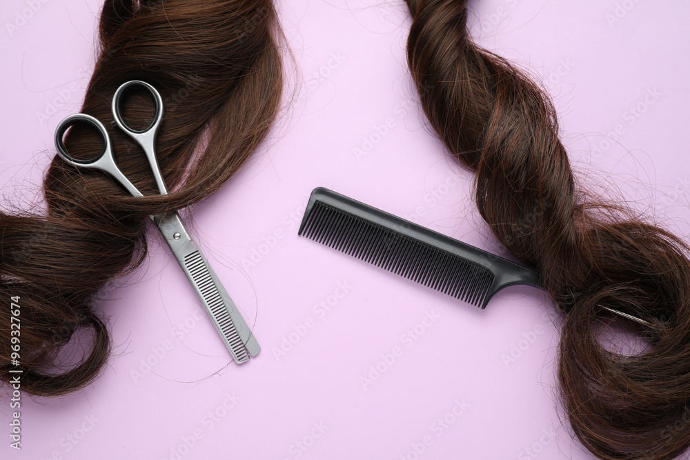 Wall mural Brown hair strand, comb and professional scissors on violet background, top view