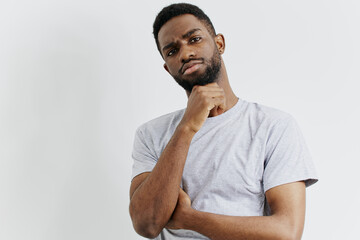 Pensive african american man contemplating with hand on chin, engaging eye contact with camera