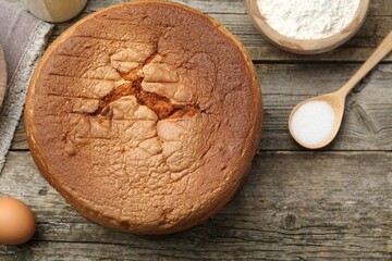 Tasty sponge cake and ingredients on wooden table, flat lay