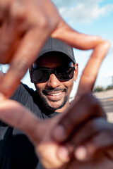 Afro black guy on the city center wearing black clothes cap an sun glasses modeling